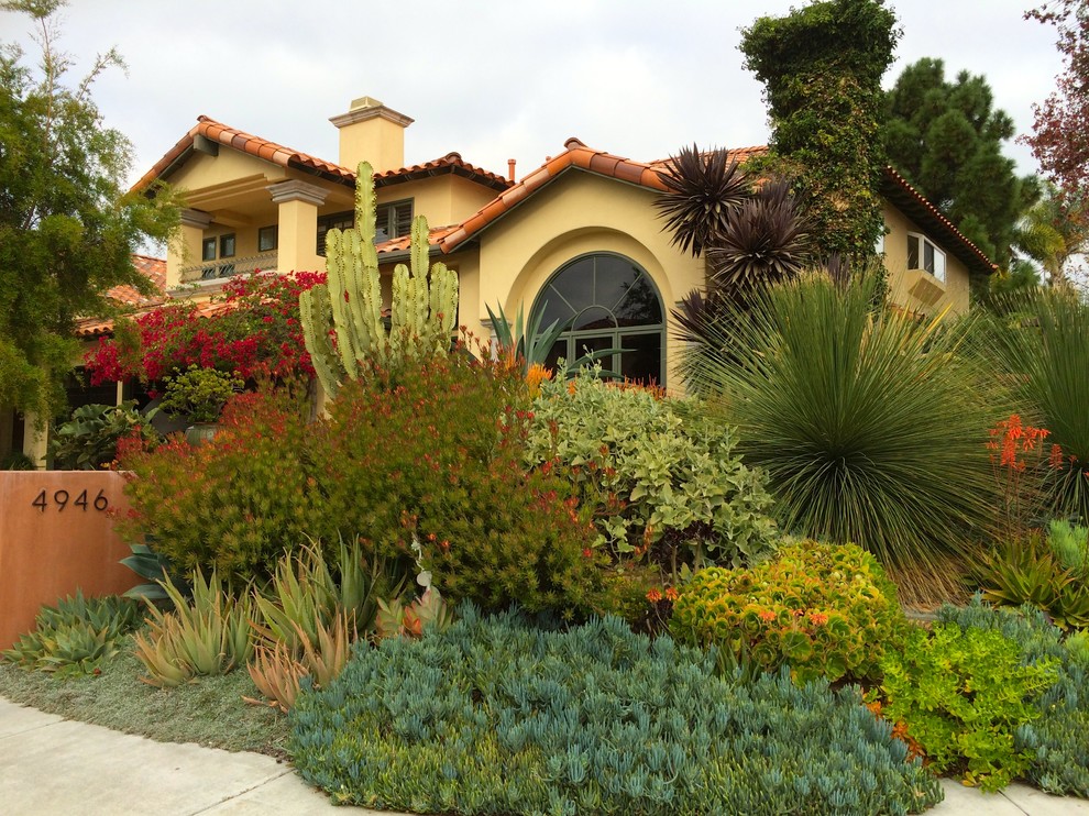 На фото: солнечный участок и сад на переднем дворе в средиземноморском стиле с хорошей освещенностью и мощением тротуарной плиткой с