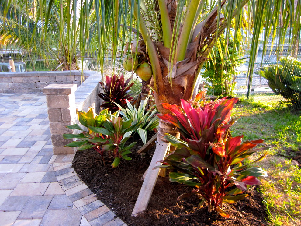 Diseño de jardín tradicional de tamaño medio en patio trasero con jardín francés, exposición parcial al sol y adoquines de ladrillo