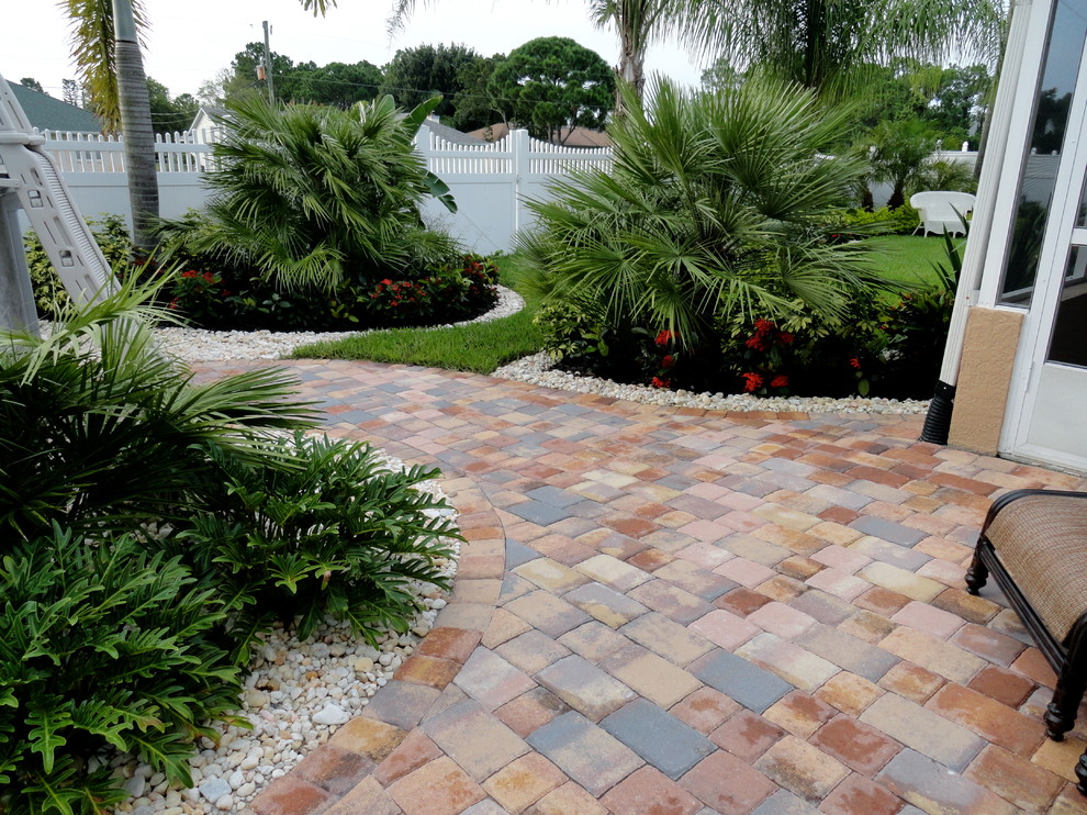 Geometrischer, Großer Klassischer Garten hinter dem Haus mit Pflastersteinen und direkter Sonneneinstrahlung in Orlando