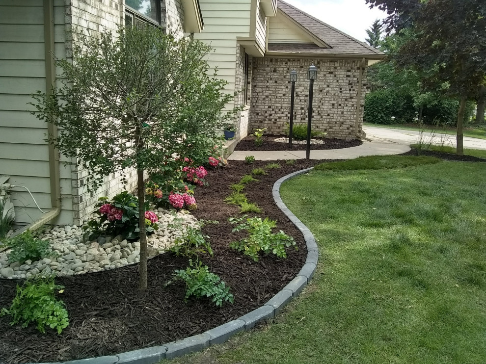 This is an example of a large transitional front yard mulch flower bed in Minneapolis.