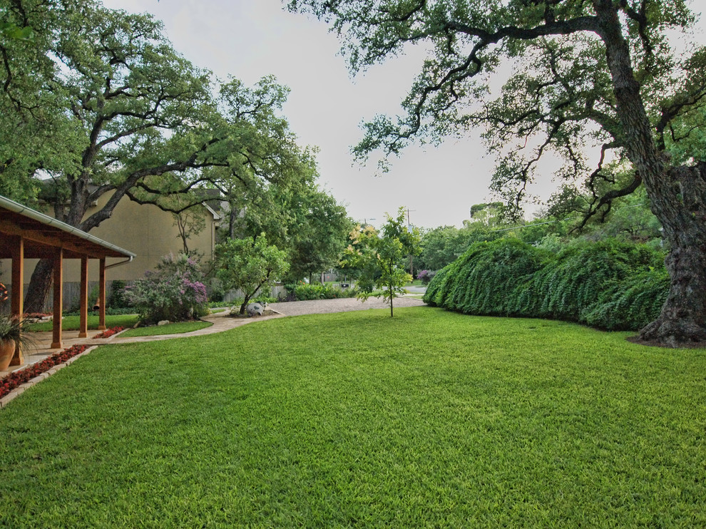 Photo of a large farmhouse full sun front yard stone landscaping in Austin for summer.