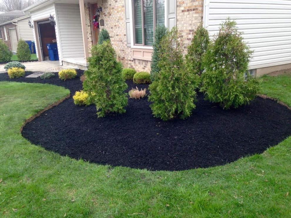 Medium sized contemporary front formal full sun garden for summer in New York with mulch.