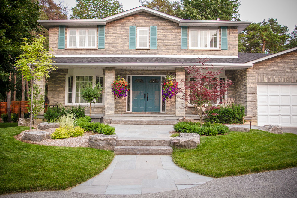 Design ideas for a medium sized contemporary front driveway partial sun garden for spring in Toronto with a garden path and natural stone paving.