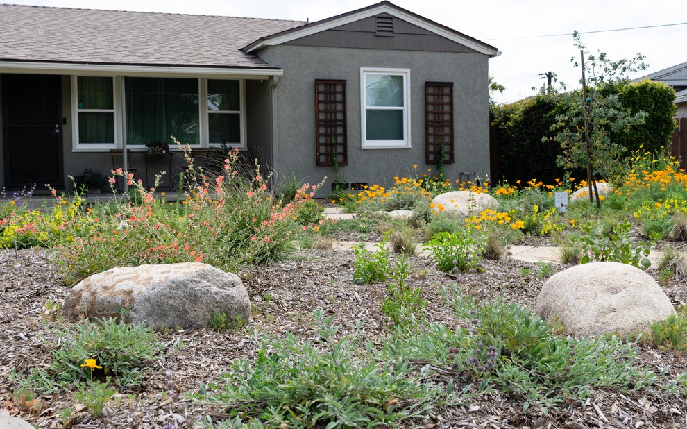 Exemple d'un jardin avant chic de taille moyenne et au printemps avec une exposition ensoleillée et des pavés en pierre naturelle.