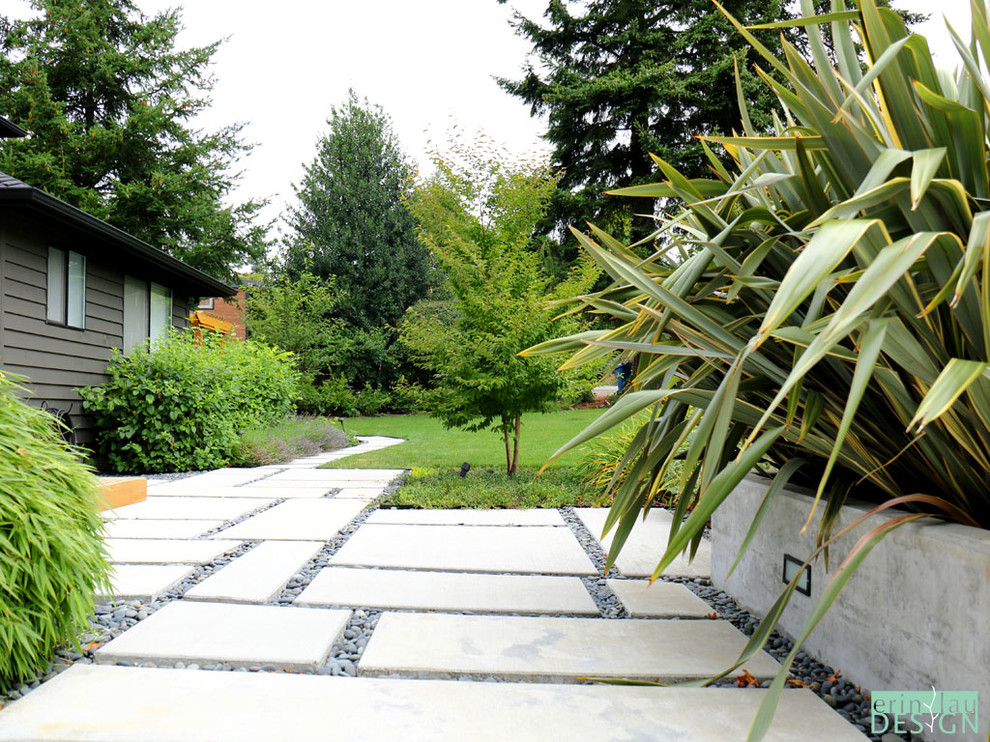 Immagine di un giardino moderno esposto in pieno sole davanti casa in estate con un ingresso o sentiero e pavimentazioni in cemento