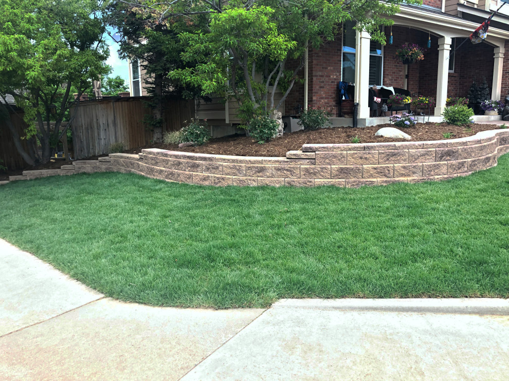 Photo of a contemporary front garden in Denver with a retaining wall and natural stone paving.