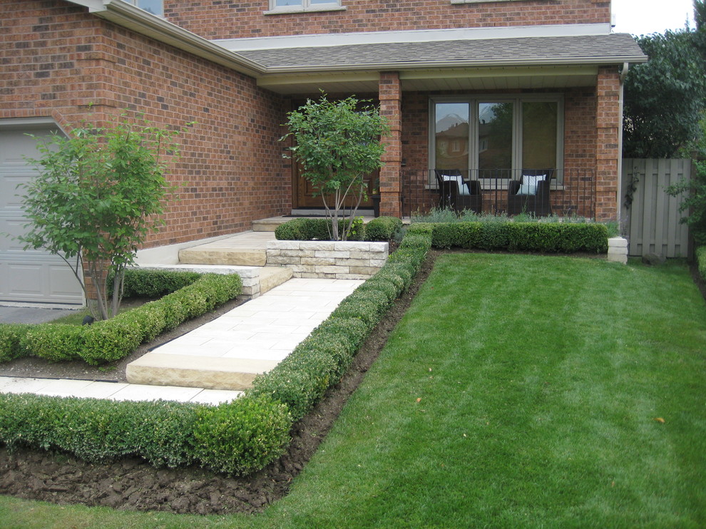 Пример оригинального дизайна: маленький солнечный, летний регулярный сад на переднем дворе в стиле модернизм с подпорной стенкой, хорошей освещенностью и покрытием из каменной брусчатки для на участке и в саду