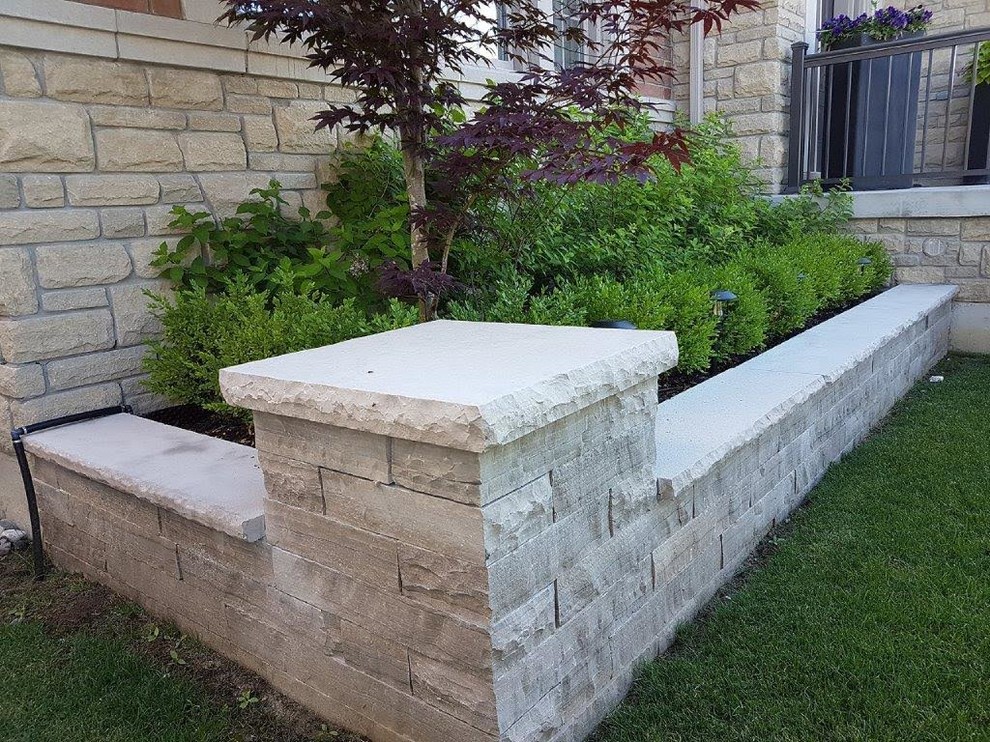 Inspiration for a mid-sized traditional front yard stone landscaping in Toronto.
