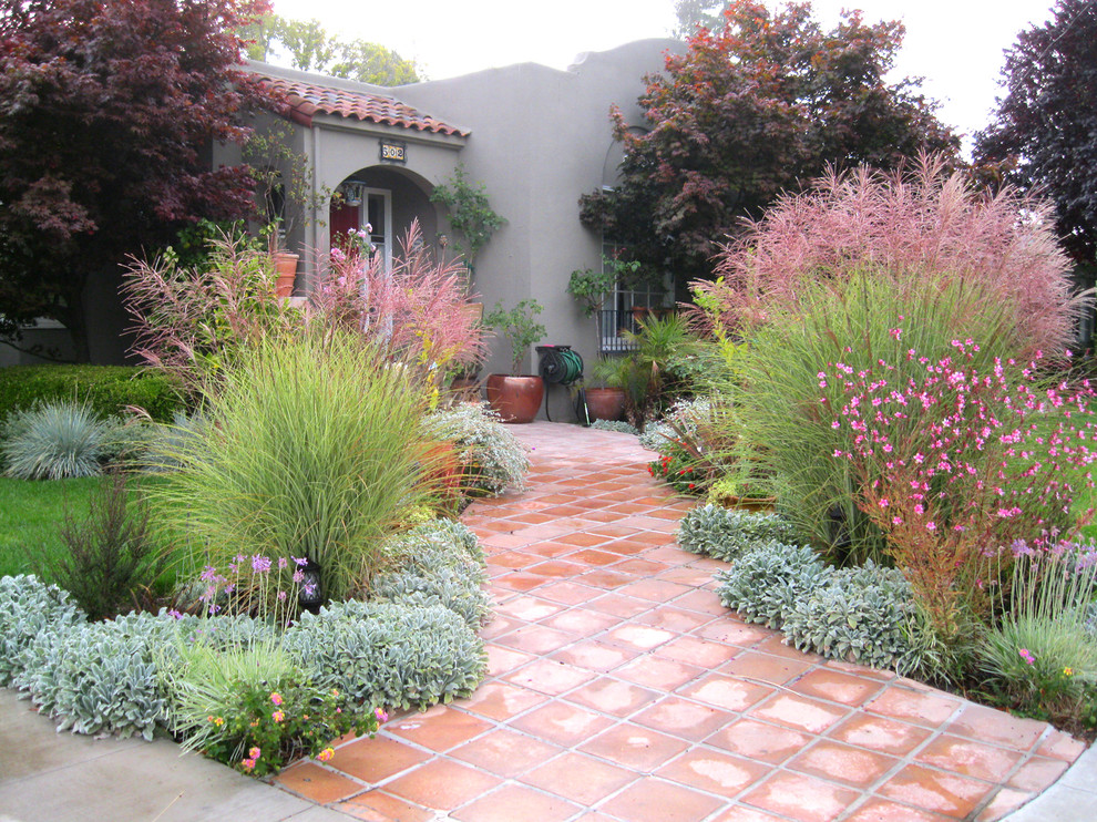 Idee per un giardino eclettico esposto in pieno sole davanti casa in primavera con un ingresso o sentiero