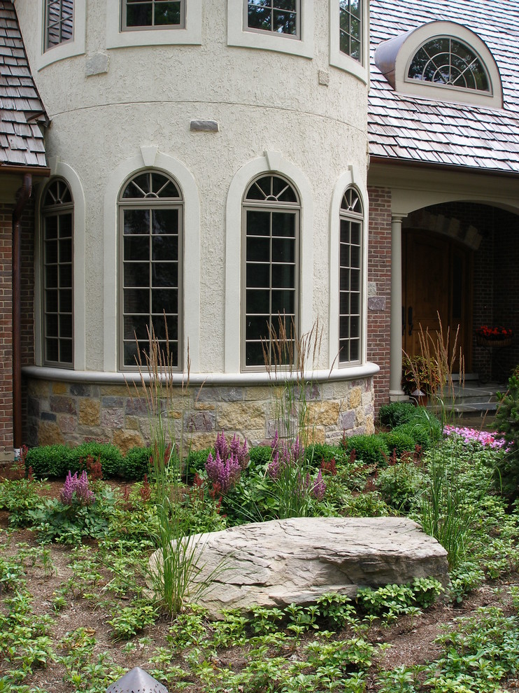 Пример оригинального дизайна: огромный регулярный сад на переднем дворе в стиле неоклассика (современная классика) с мульчированием