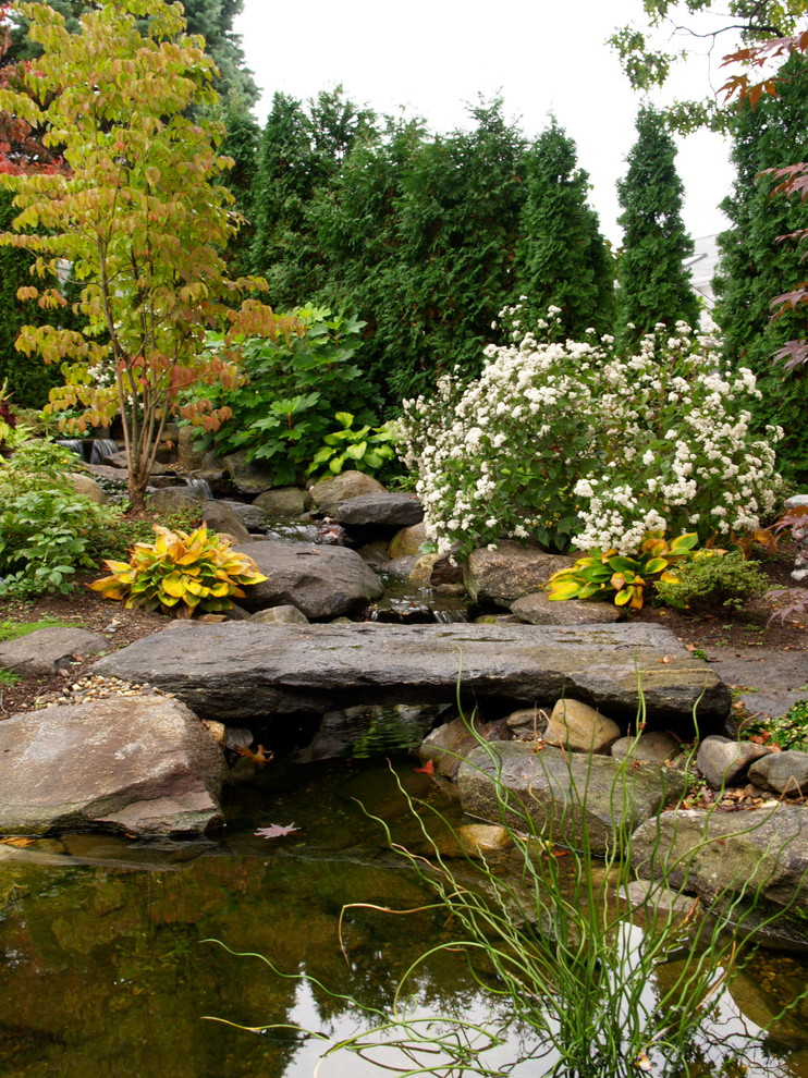 Immagine di un piccolo giardino etnico in ombra in autunno con fontane, un pendio, una collina o una riva e pavimentazioni in pietra naturale