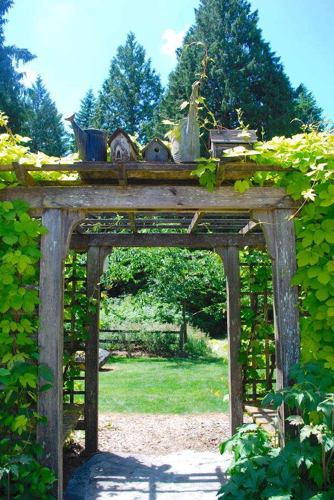 Foto på en liten vintage trädgård i delvis sol på sommaren, med marksten i tegel