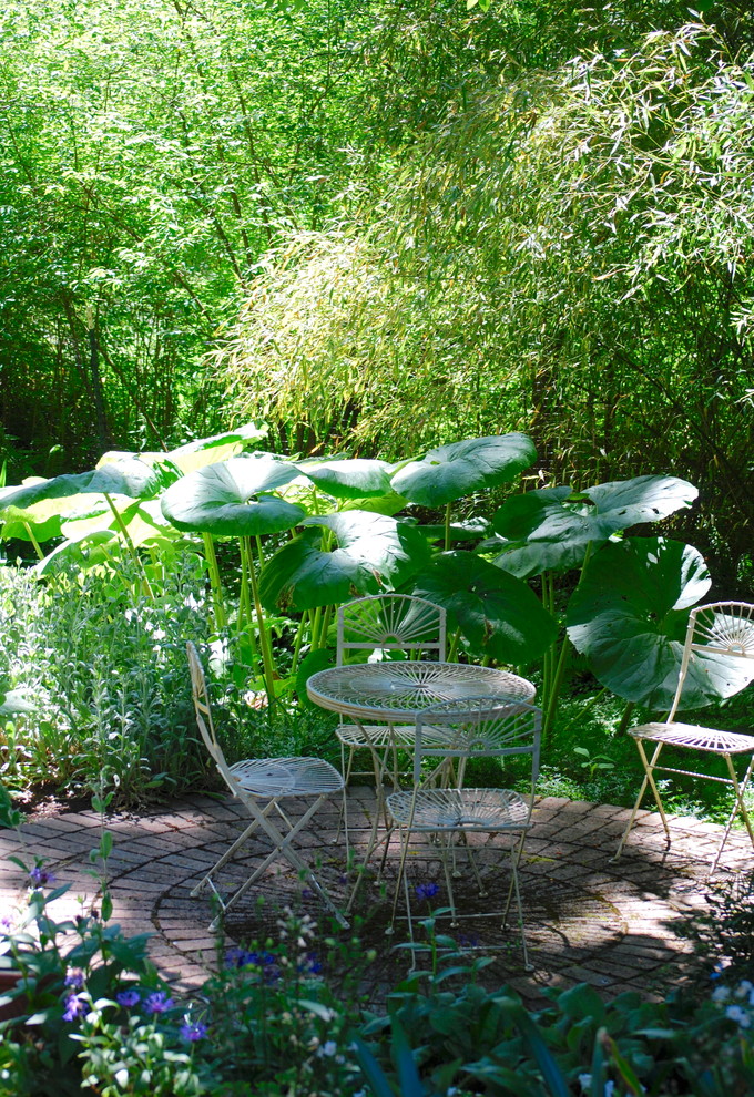 Idéer för att renovera en mellanstor eklektisk trädgård i skuggan på sommaren, med marksten i tegel