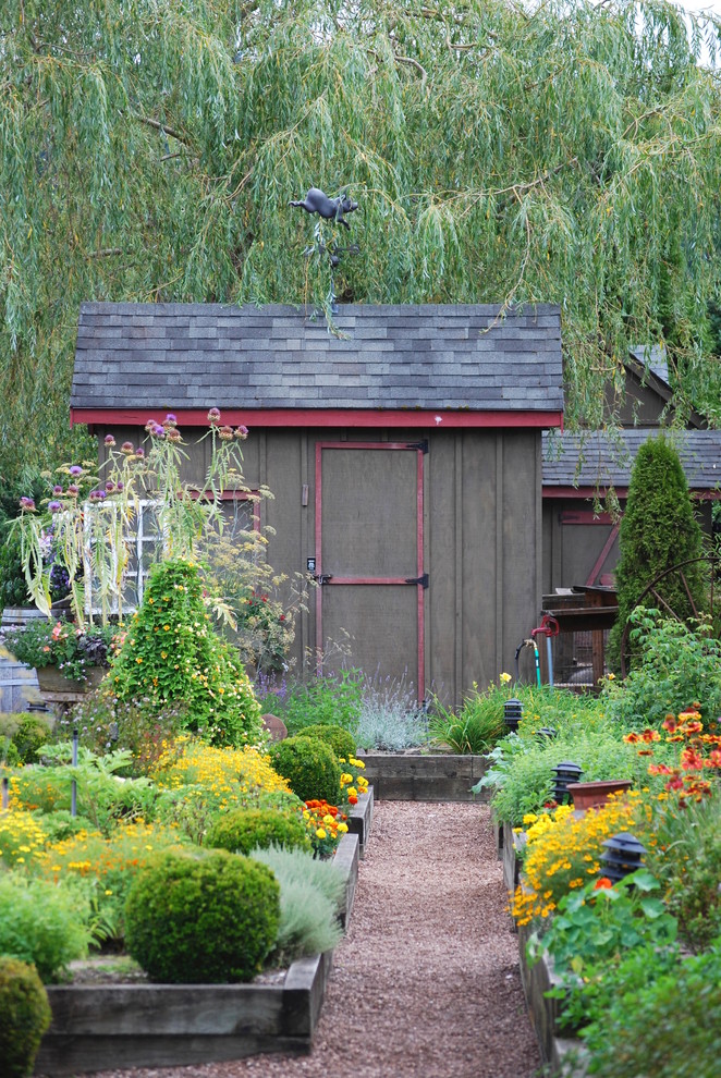 Imagen de jardín clásico de tamaño medio en verano en patio delantero con jardín francés, huerto, exposición total al sol y mantillo