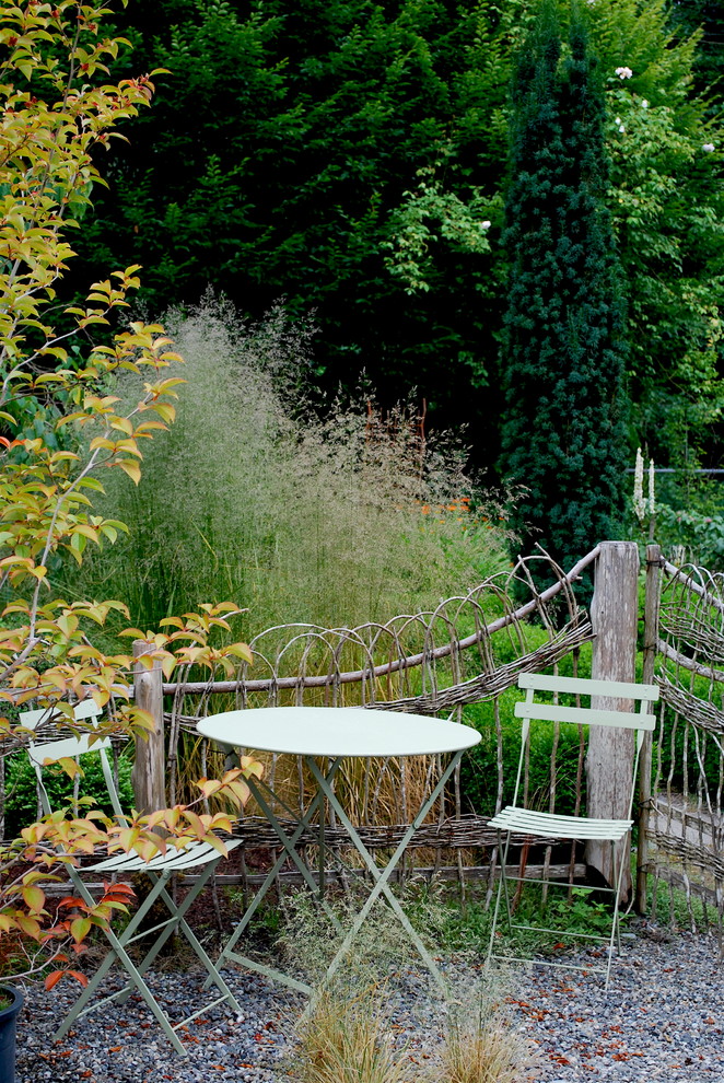 Foto di un piccolo giardino formale rustico esposto a mezz'ombra dietro casa in autunno con ghiaia