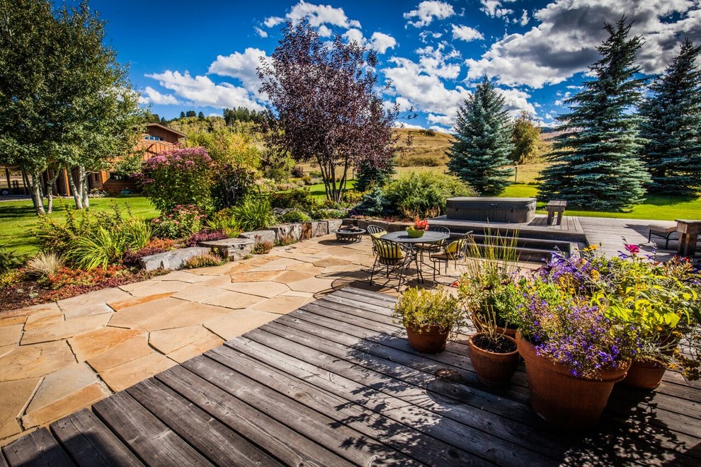 This is an example of a mid-sized craftsman full sun backyard stone landscaping in Other for spring.