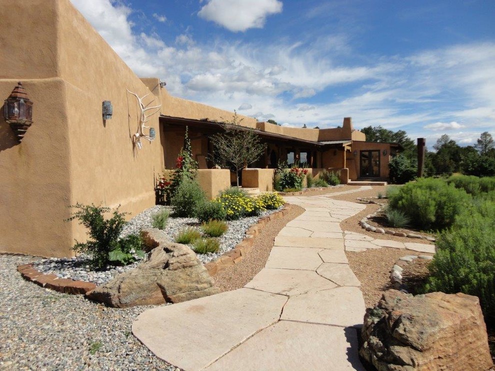 Design ideas for a large southwestern drought-tolerant and partial sun front yard gravel landscaping in Albuquerque.