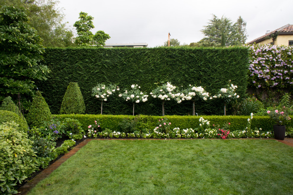 На фото: солнечный регулярный сад в классическом стиле с хорошей освещенностью