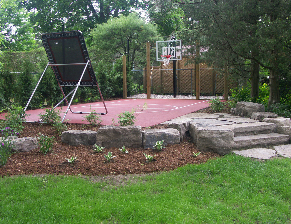 This is an example of a large traditional full sun backyard stone landscaping in Dallas.