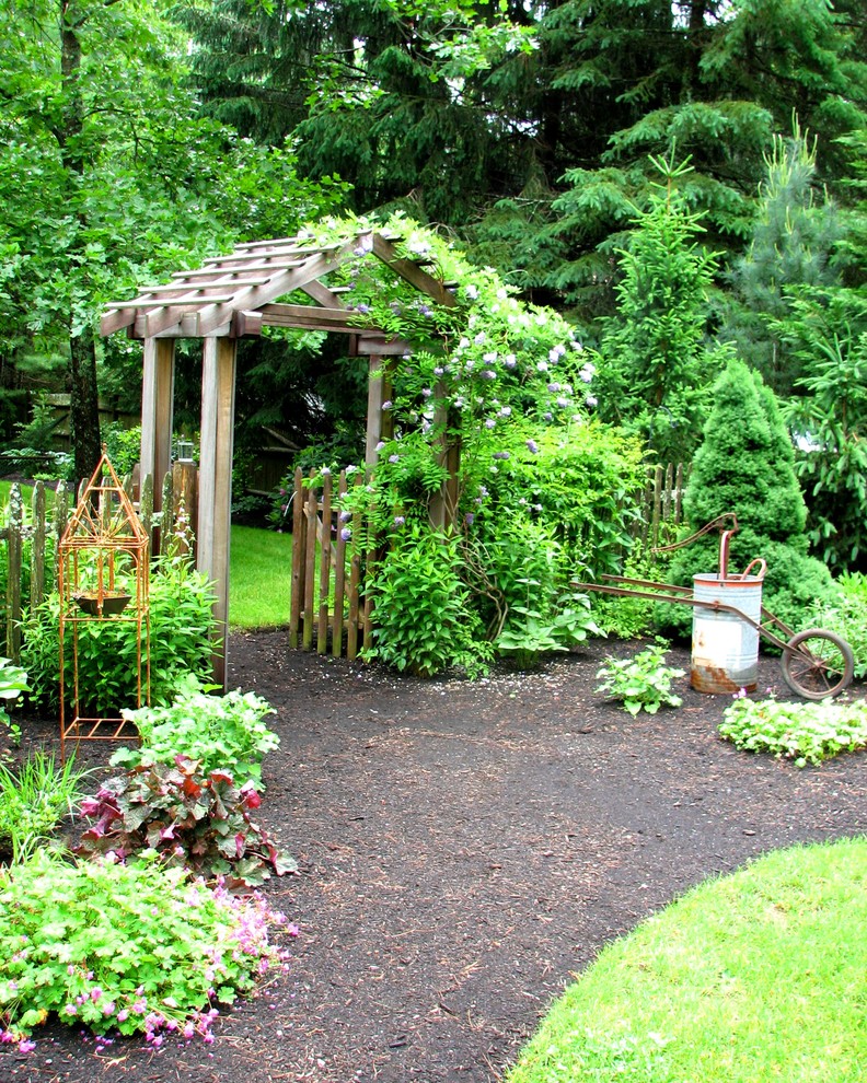 На фото: большой солнечный, летний участок и сад на переднем дворе в классическом стиле с садовой дорожкой или калиткой, хорошей освещенностью и мульчированием