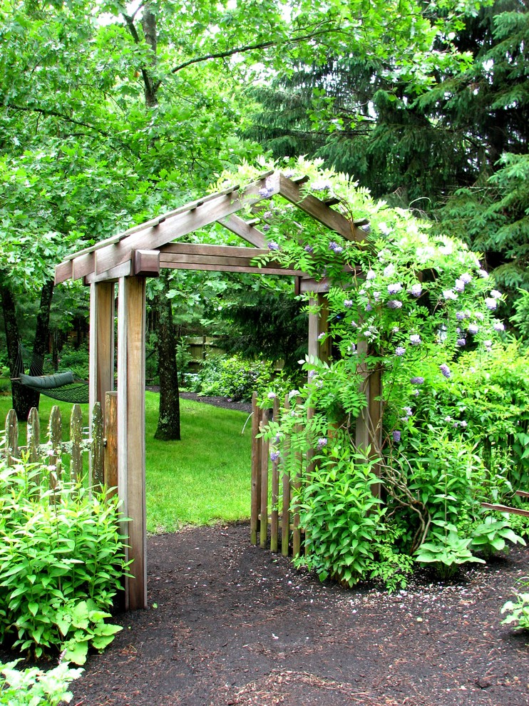 Пример оригинального дизайна: большой тенистый, весенний участок и сад на переднем дворе в классическом стиле с садовой дорожкой или калиткой и мульчированием