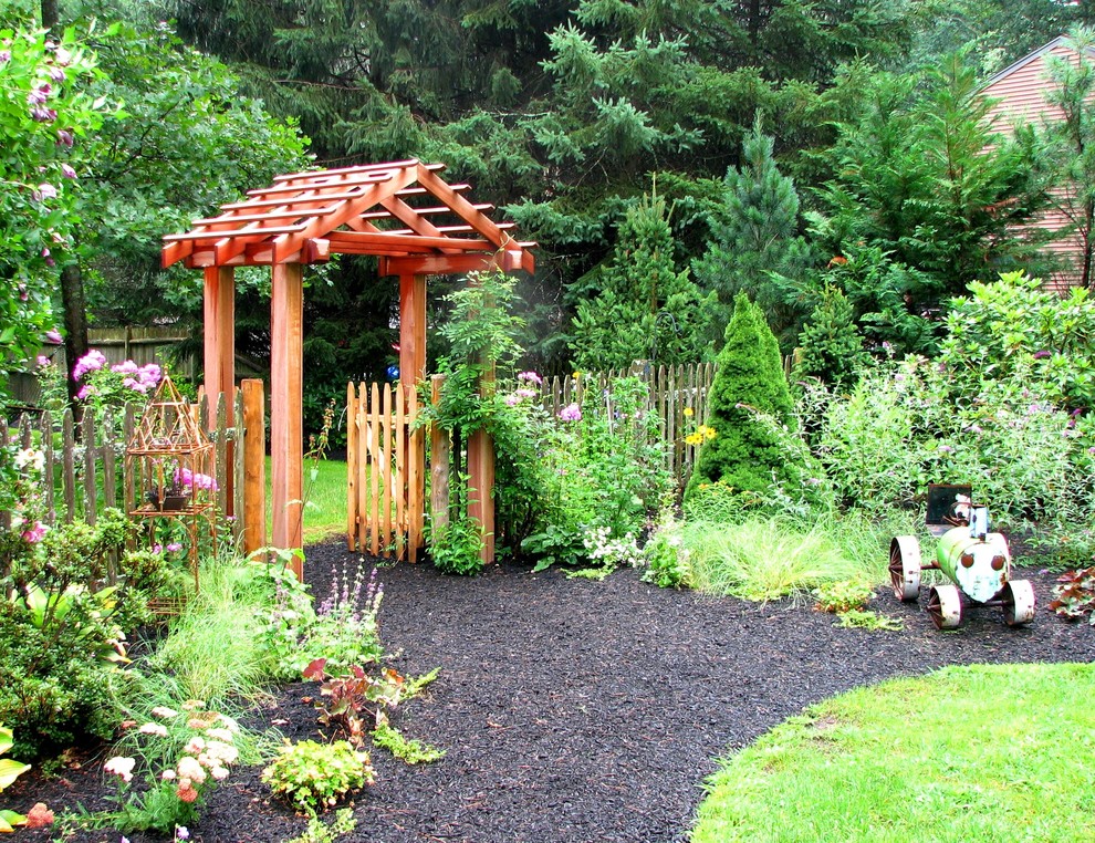 Immagine di un giardino chic esposto in pieno sole davanti casa in estate con pacciame e un ingresso o sentiero