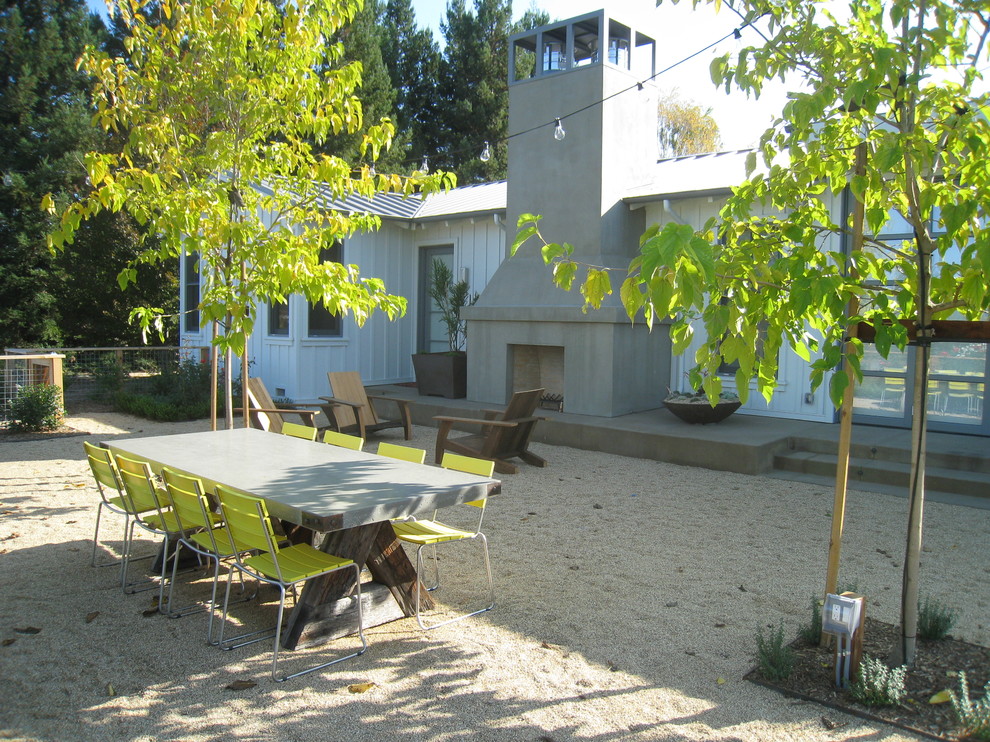 Идея дизайна: двор на внутреннем дворе в стиле кантри с покрытием из гравия и уличным камином