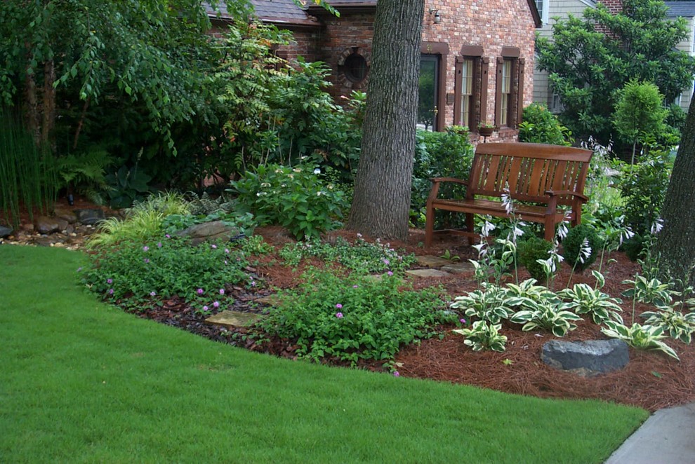 Ejemplo de jardín clásico de tamaño medio en patio trasero con exposición reducida al sol y adoquines de piedra natural