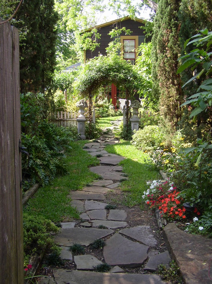 Imagen de camino de jardín tradicional pequeño en verano en patio trasero con jardín francés, exposición parcial al sol y mantillo