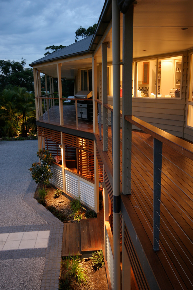 This is an example of a large contemporary front driveway full sun garden for summer in Brisbane with a garden path and concrete paving.