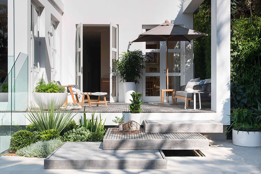 Idee per un piccolo giardino minimal esposto in pieno sole dietro casa con fontane e pavimentazioni in cemento