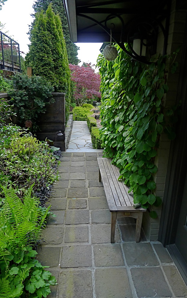 Photo of a small craftsman partial sun side yard stone retaining wall landscape in Seattle.