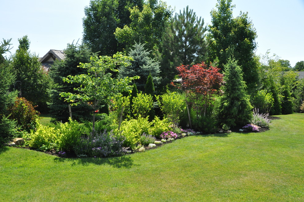 Inspiration for an expansive traditional back full sun garden for summer in Kansas City with mulch.