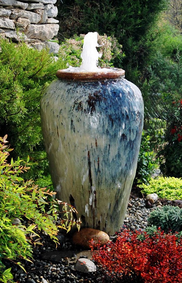 Inspiration pour un jardin arrière traditionnel de taille moyenne avec un point d'eau, une exposition ensoleillée et du gravier.
