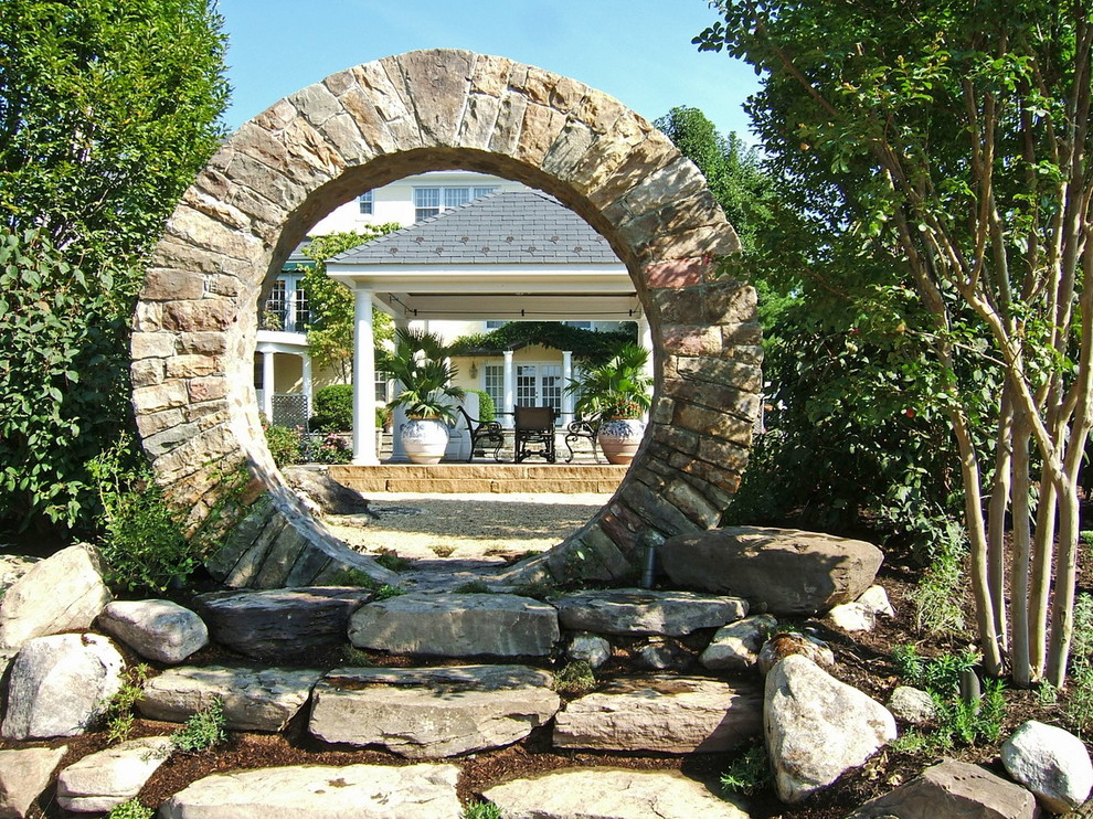 Inspiration pour un jardin arrière traditionnel avec des pavés en pierre naturelle.