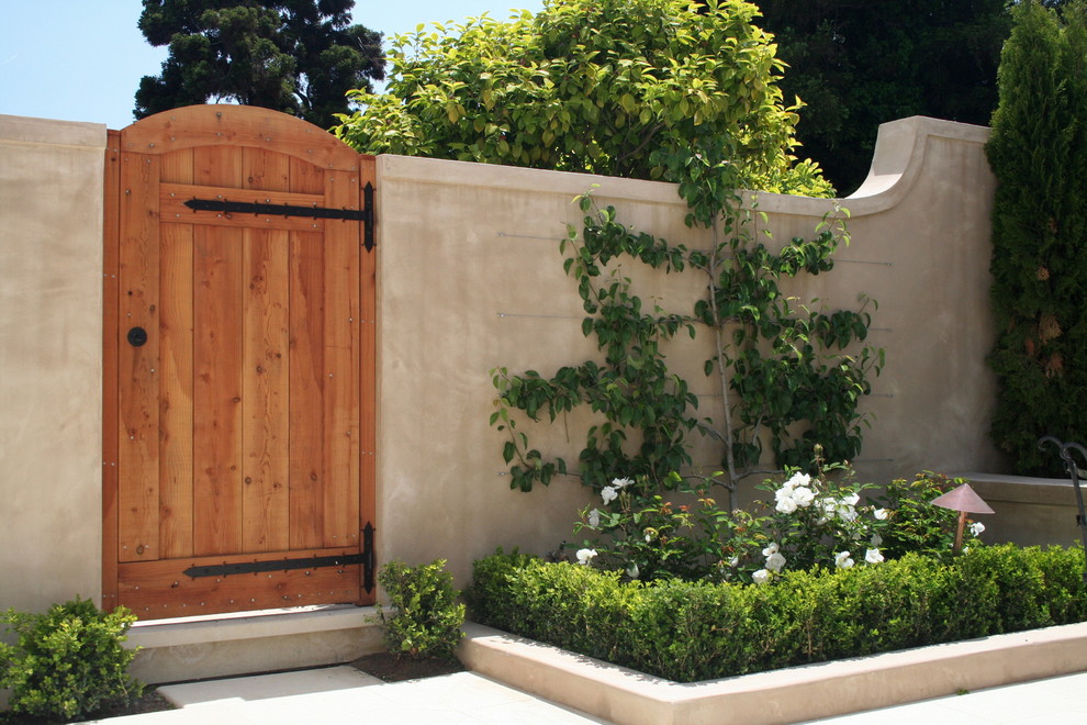Immagine di un piccolo giardino formale classico dietro casa con pavimentazioni in pietra naturale e scale