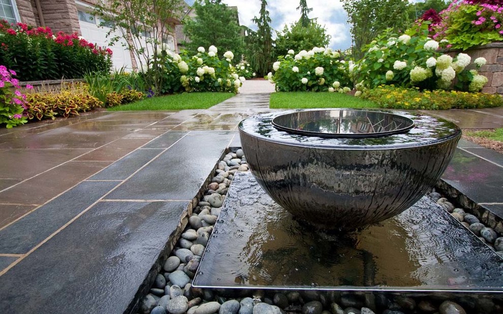 Design ideas for a mid-sized traditional shade front yard concrete paver water fountain landscape in Toronto for spring.