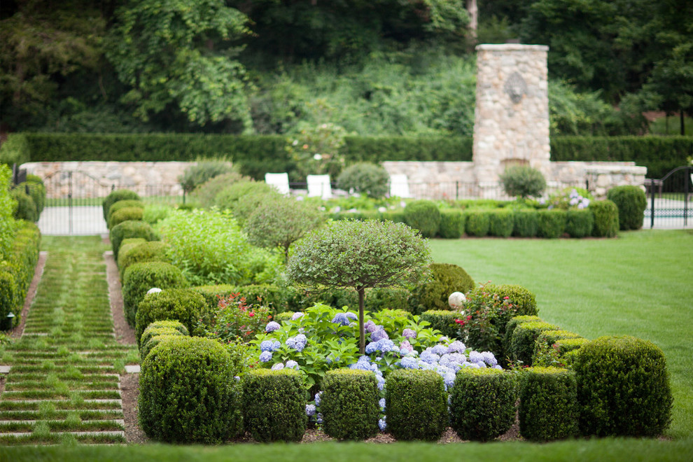 Design ideas for a large traditional full sun side yard stone formal garden in New York for summer.