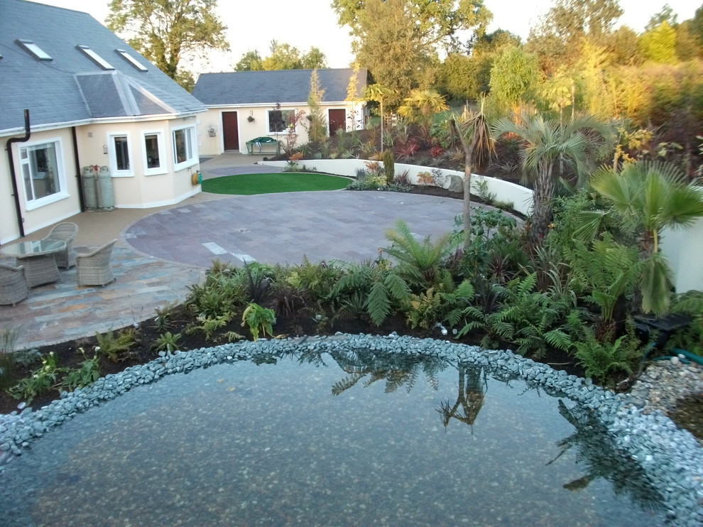 Immagine di un grande giardino formale minimal esposto in pieno sole dietro casa in estate con pavimentazioni in pietra naturale