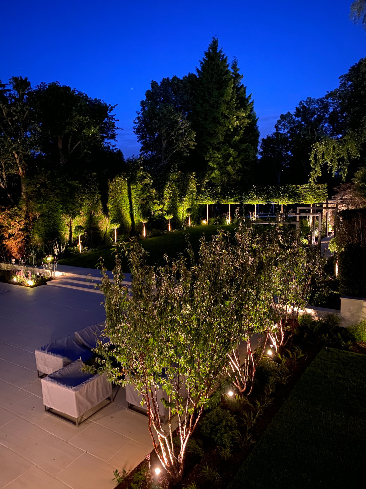Geometrischer, Großer Moderner Garten hinter dem Haus mit Natursteinplatten in Hertfordshire