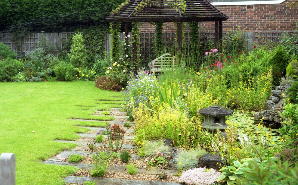 Foto de jardín tradicional de tamaño medio en verano en patio trasero con exposición parcial al sol