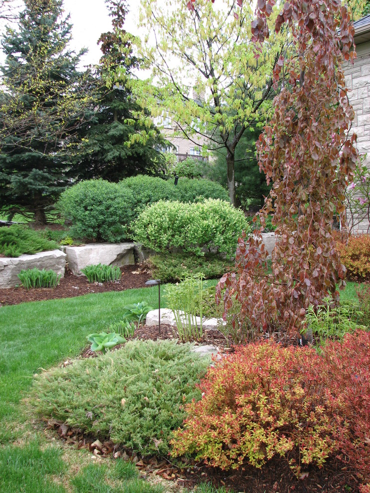 This is an example of a traditional garden in Toronto with a water feature.