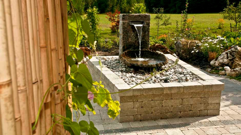 Esempio di un grande giardino formale minimalista dietro casa con fontane e pavimentazioni in cemento