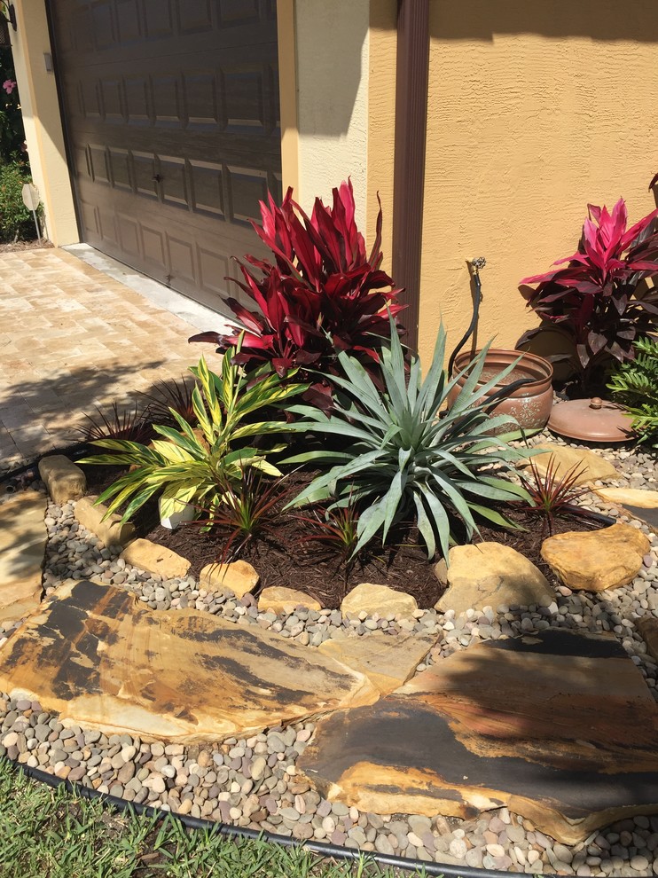 Diseño de camino de jardín tropical grande en patio lateral con exposición parcial al sol y adoquines de piedra natural