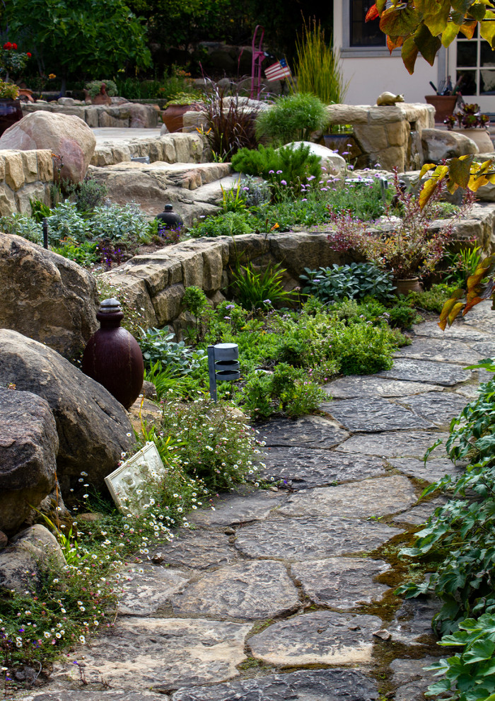 Foto de jardín de secano actual de tamaño medio en verano en patio con brasero, exposición parcial al sol y adoquines de piedra natural