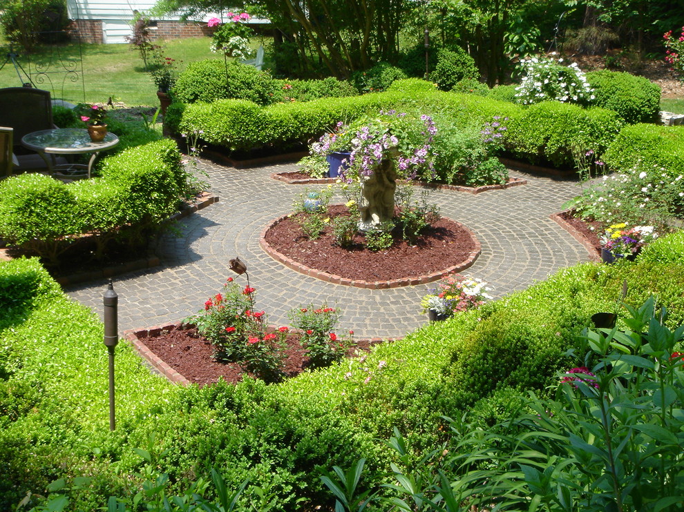 На фото: регулярный сад на заднем дворе в классическом стиле с покрытием из каменной брусчатки