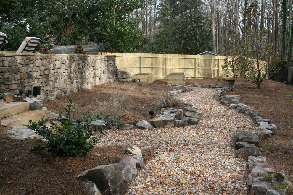Imagen de jardín rústico grande en verano en patio trasero con jardín francés, camino de entrada, exposición parcial al sol y piedra decorativa