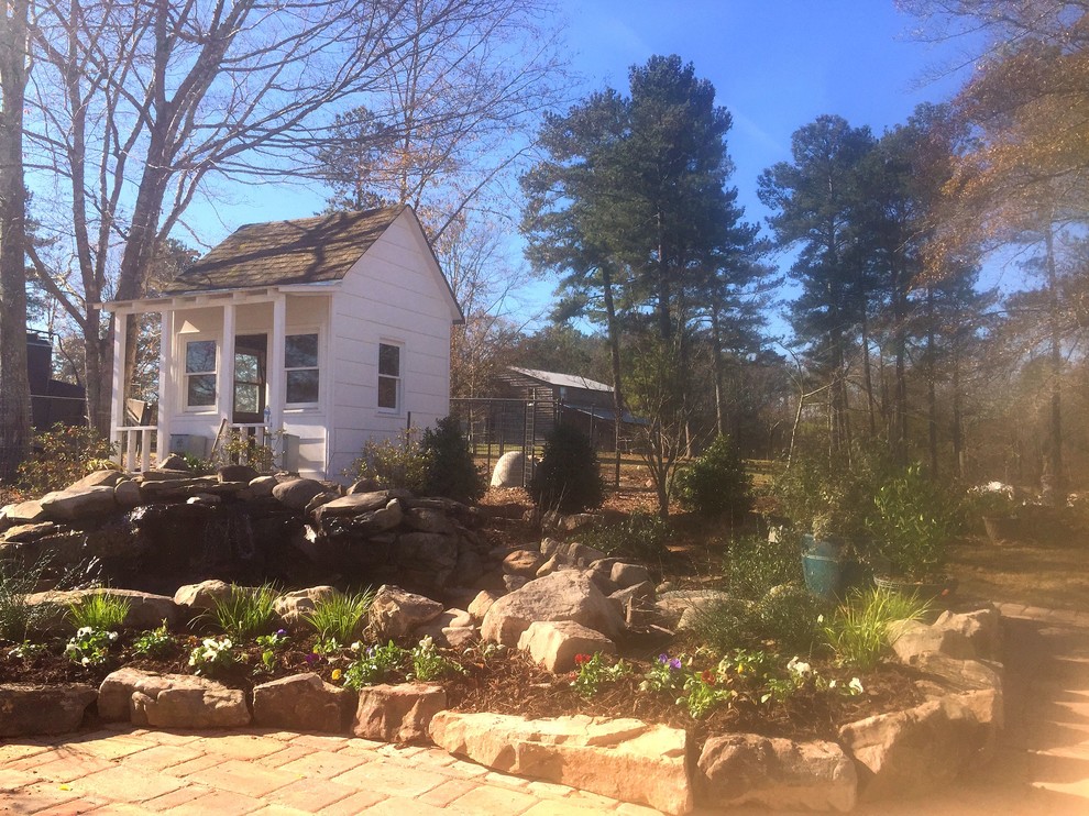 Design ideas for a medium sized country back formal full sun garden for summer in Atlanta with a pond and decorative stones.
