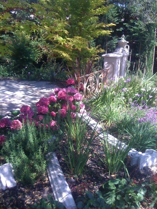 Diseño de camino de jardín clásico grande en verano en patio lateral con jardín francés, exposición reducida al sol y gravilla