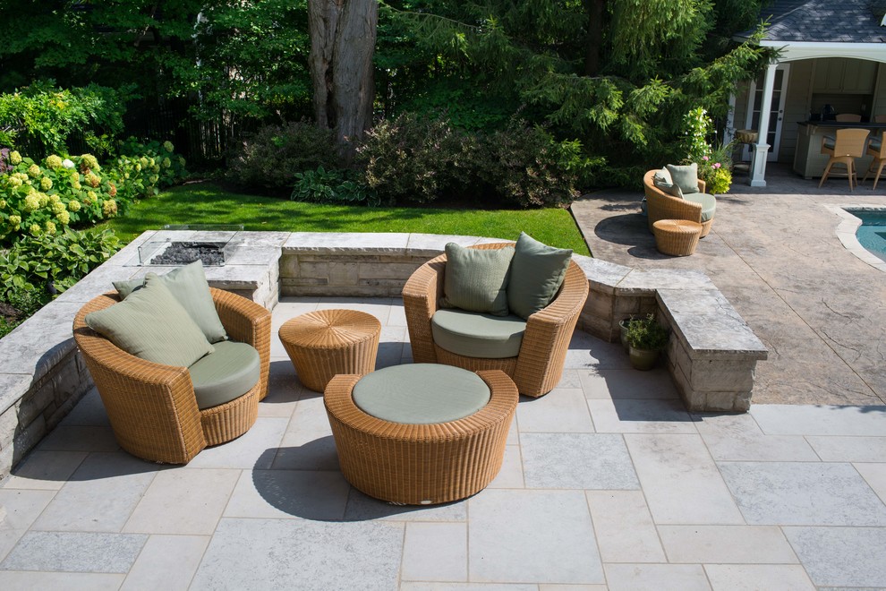 Diseño de patio actual en patio trasero con adoquines de piedra natural